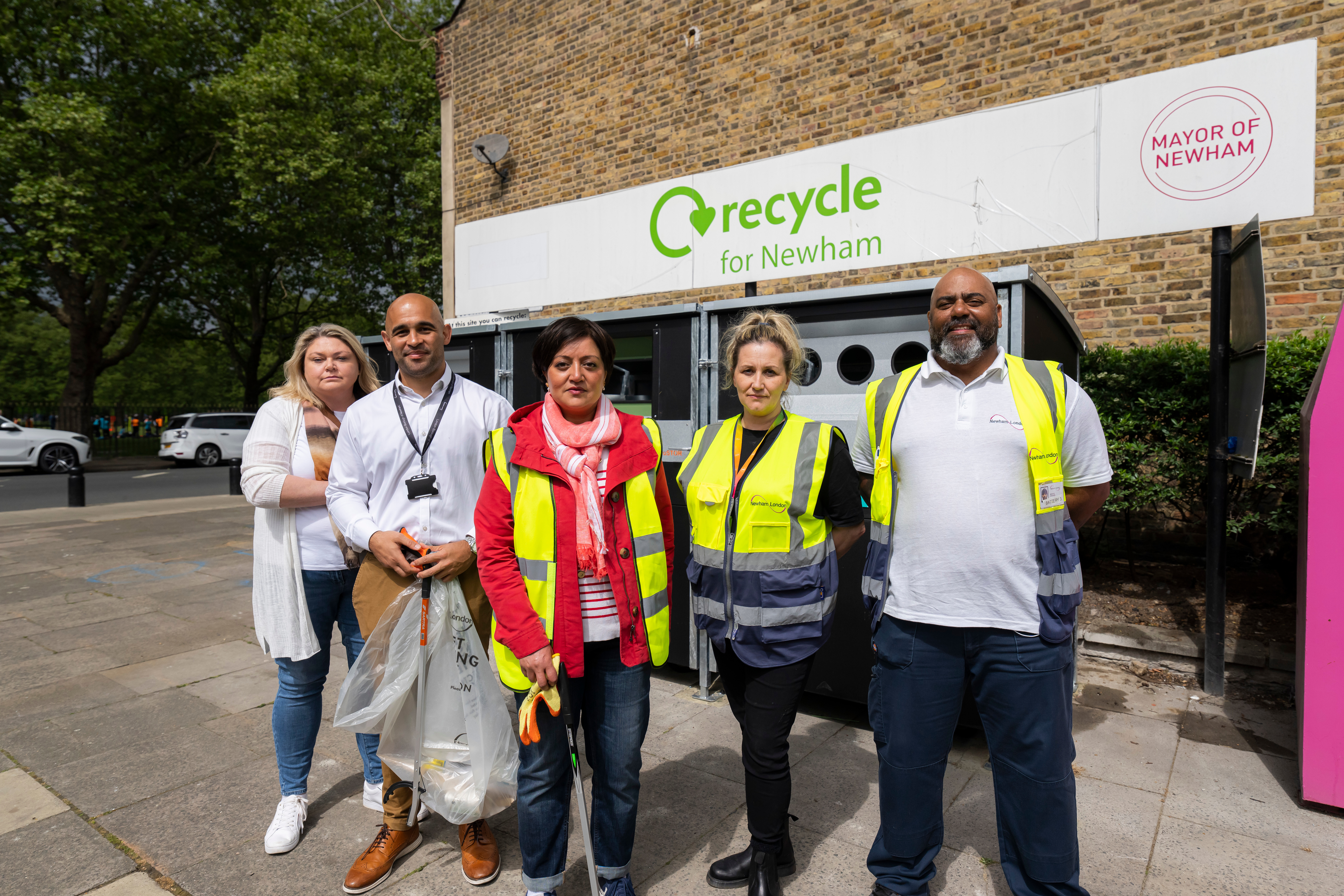 Image of the Mayor and others in front of a 'recycle for newham' sign