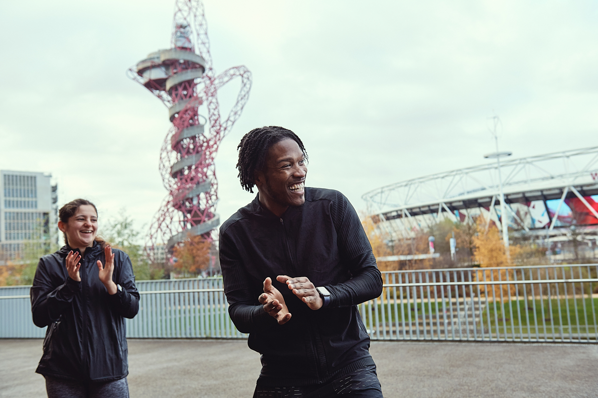 A man and a woman encouraging and clapping for others to get fit