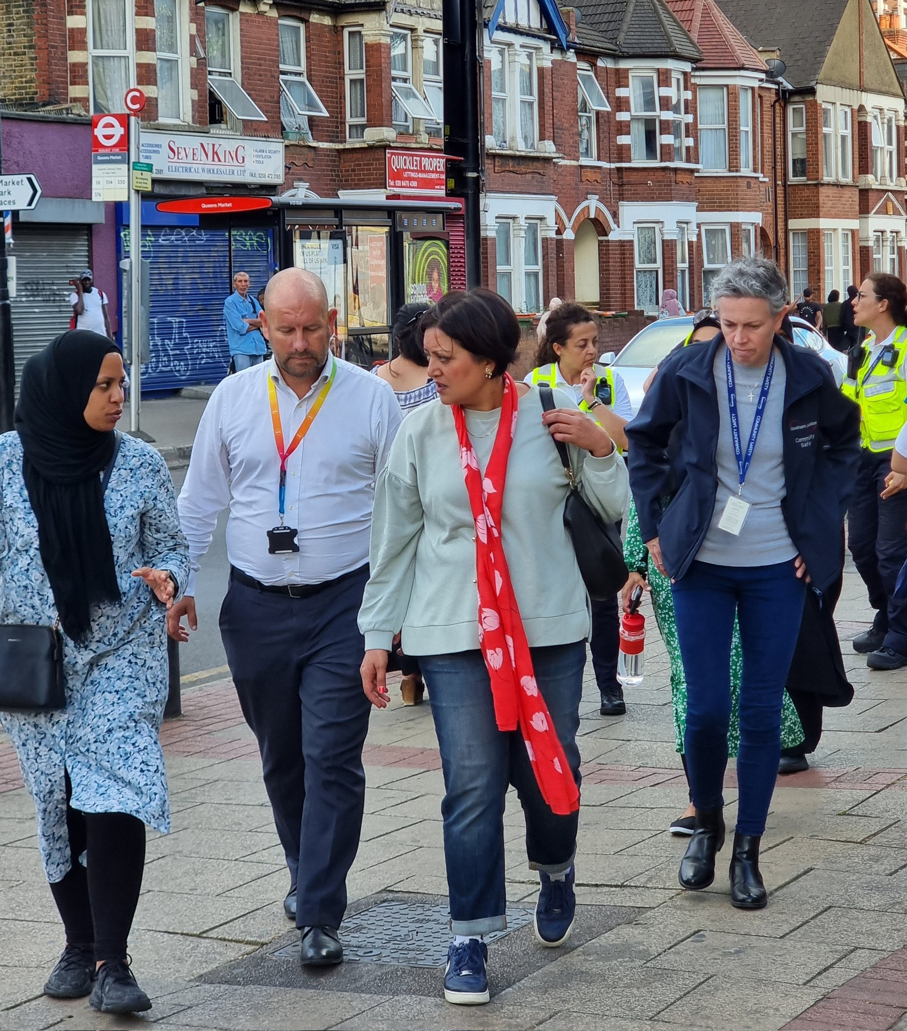 Mayor walking with colleagues and resident