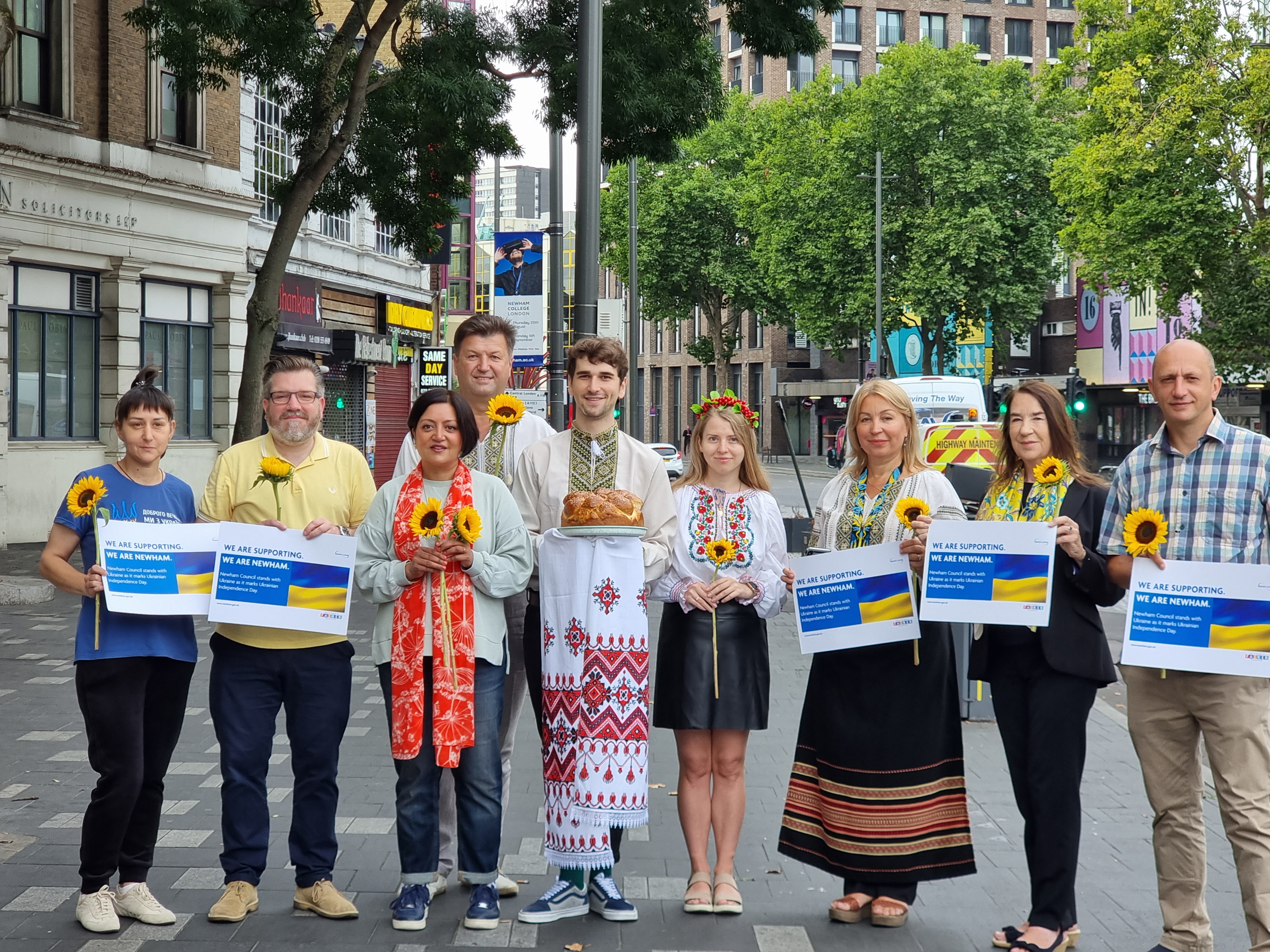 Mayor of Newham holding sunflower with ukranian residents to mark ukranian independence day
