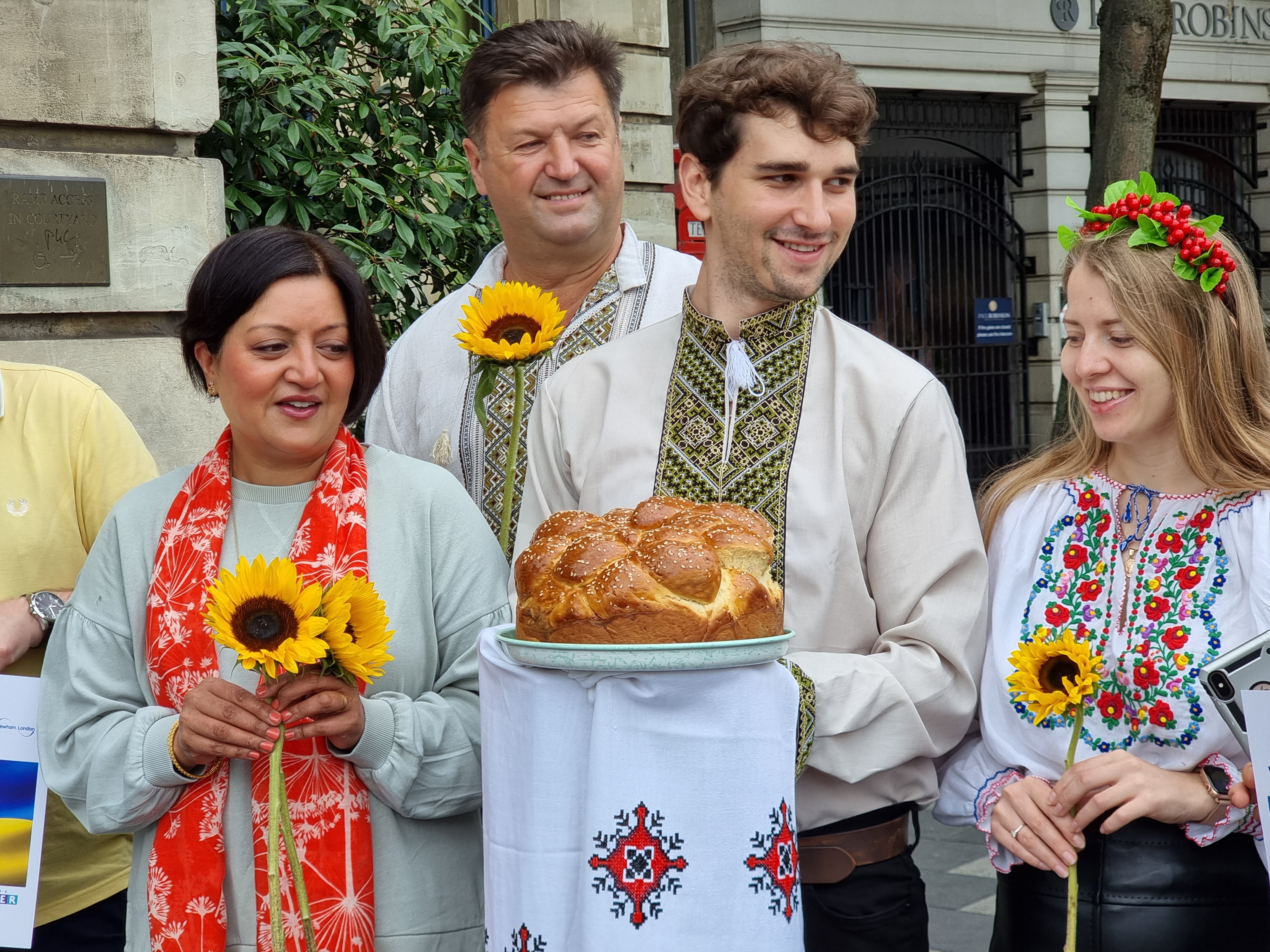 Mayor of Newham holding sunflower with ukranian residents to mark ukranian independence day