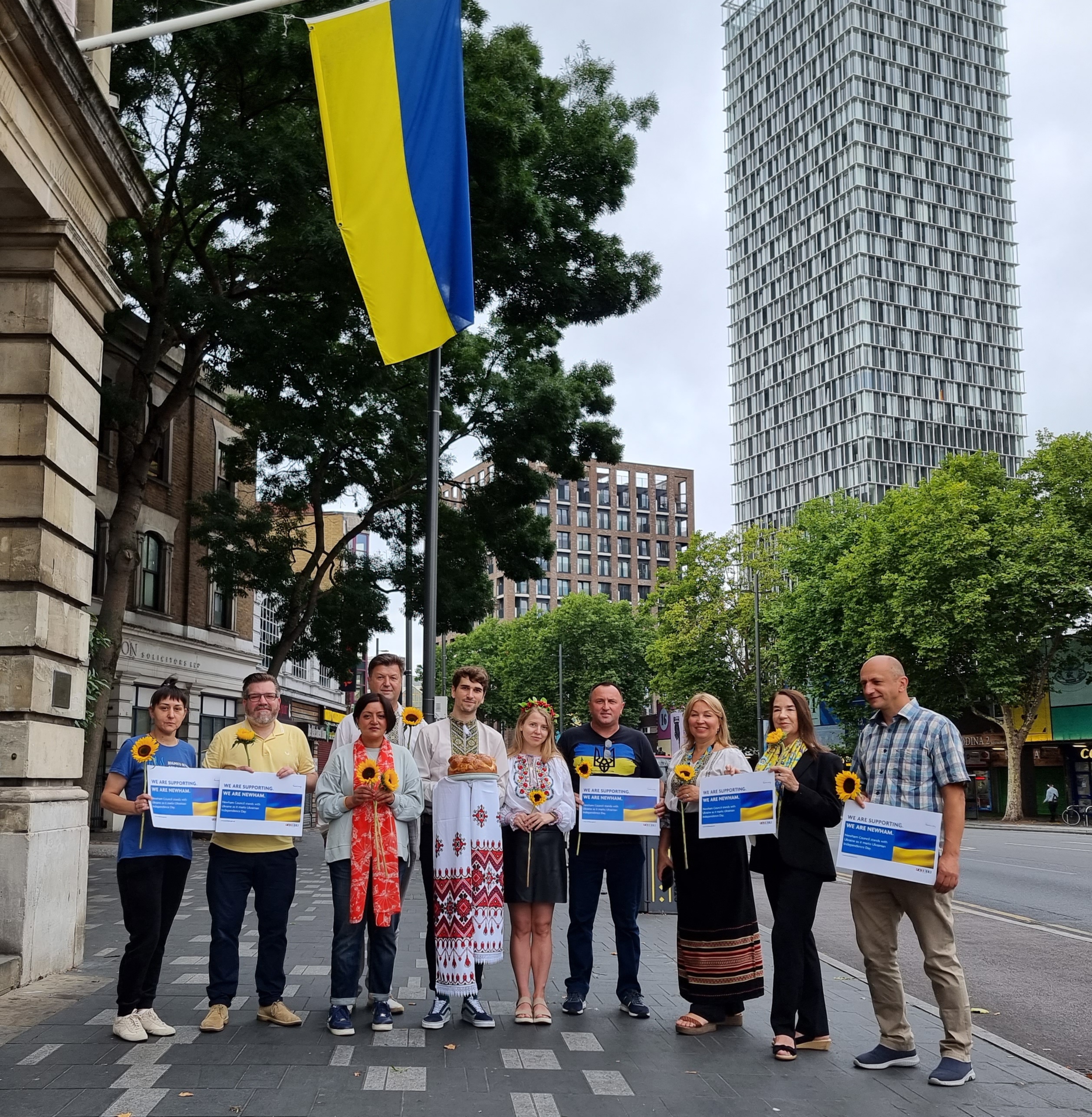 Mayor of Newham holding sunflower with ukranian residents to mark ukranian independence day