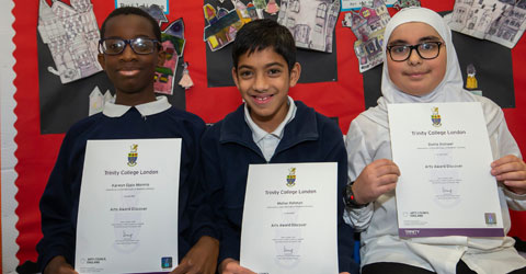 Three children posing with their certificates