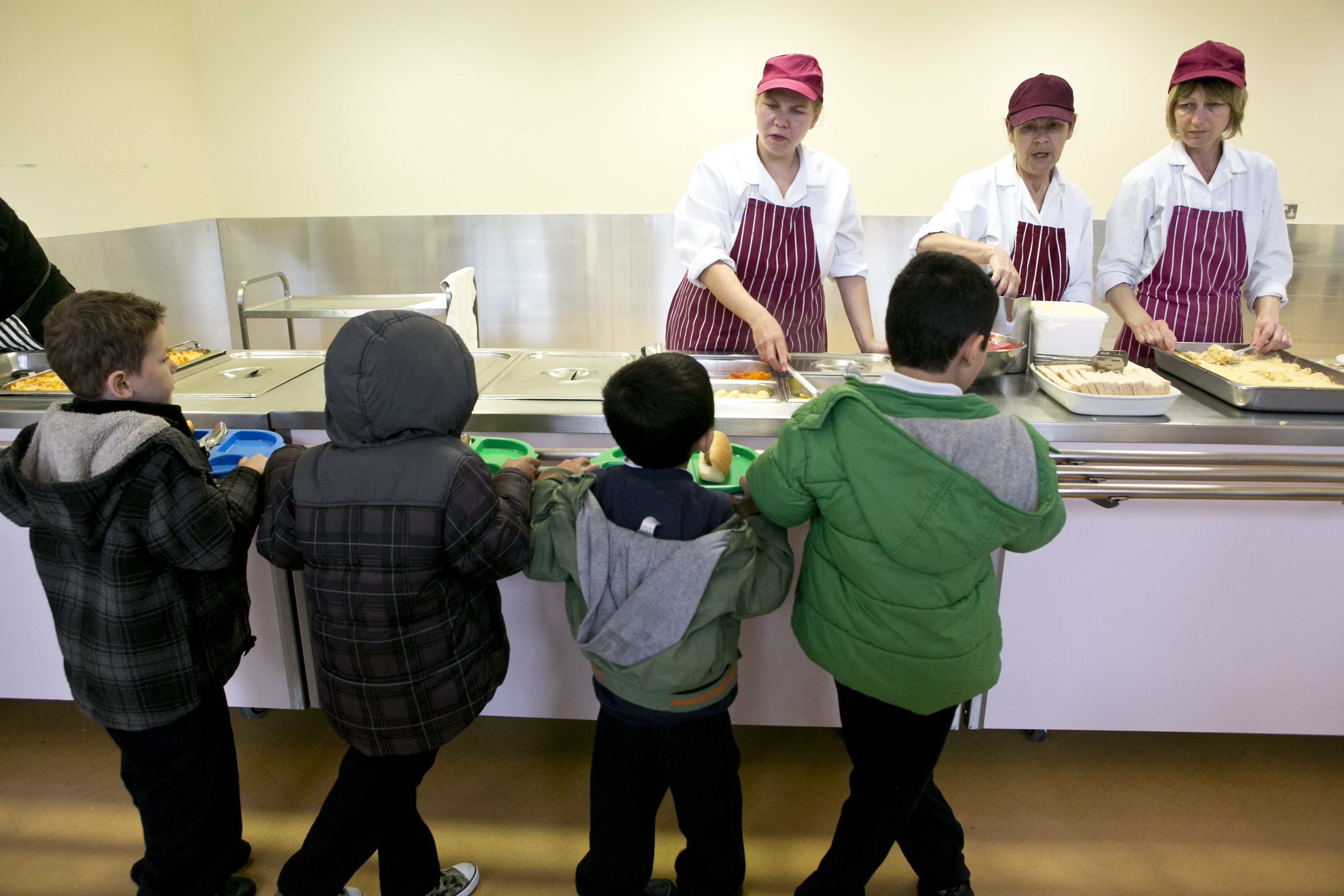 Children are getting their free school meal in the canteen.