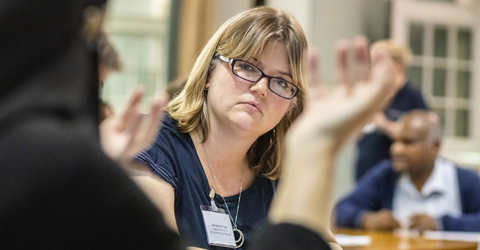 A woman listening to a discussion about how environmental crime can be tackled at a forum