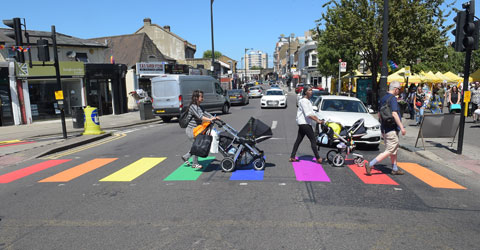 Residents crossing a rainbow pedestrian crossing