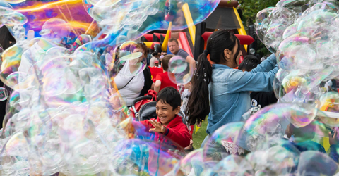 Children and adults playing with bubbles in Newham Show 2019.