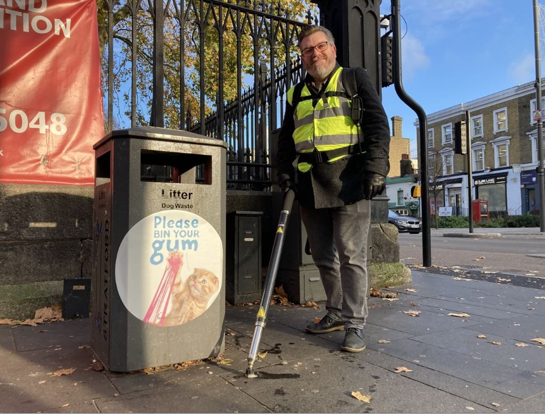 Cllr James Asser near a bin with a chewing gum cleaning machine