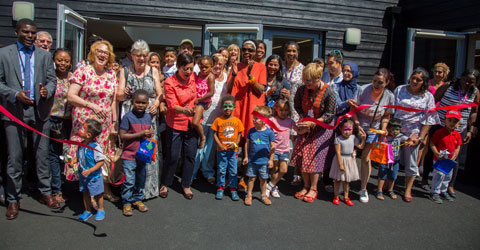 Mayor of Newham Rokhsana Fiaz cutting the ribbon at the launch of a nursery service with kids, parents and staff.