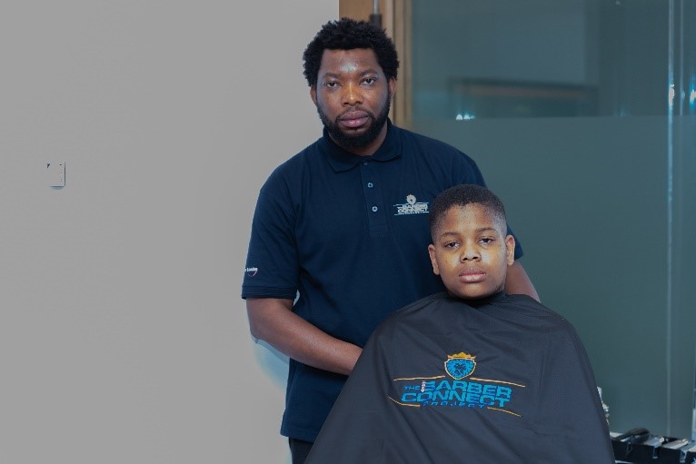 King Ogunremi [pictured], founder of the Barber Connect project funded by Newham’s People Powered Places programme, poses with teen during Barber Connect event.